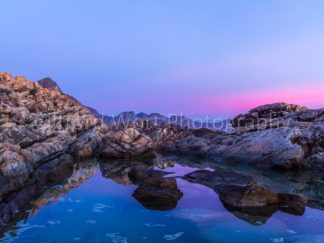 Colourful sunset along a rocky coast in Cape Town